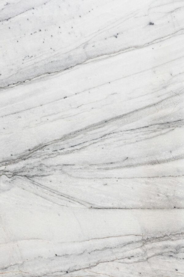 Close-up of a textured white marble surface with natural lines and patterns.